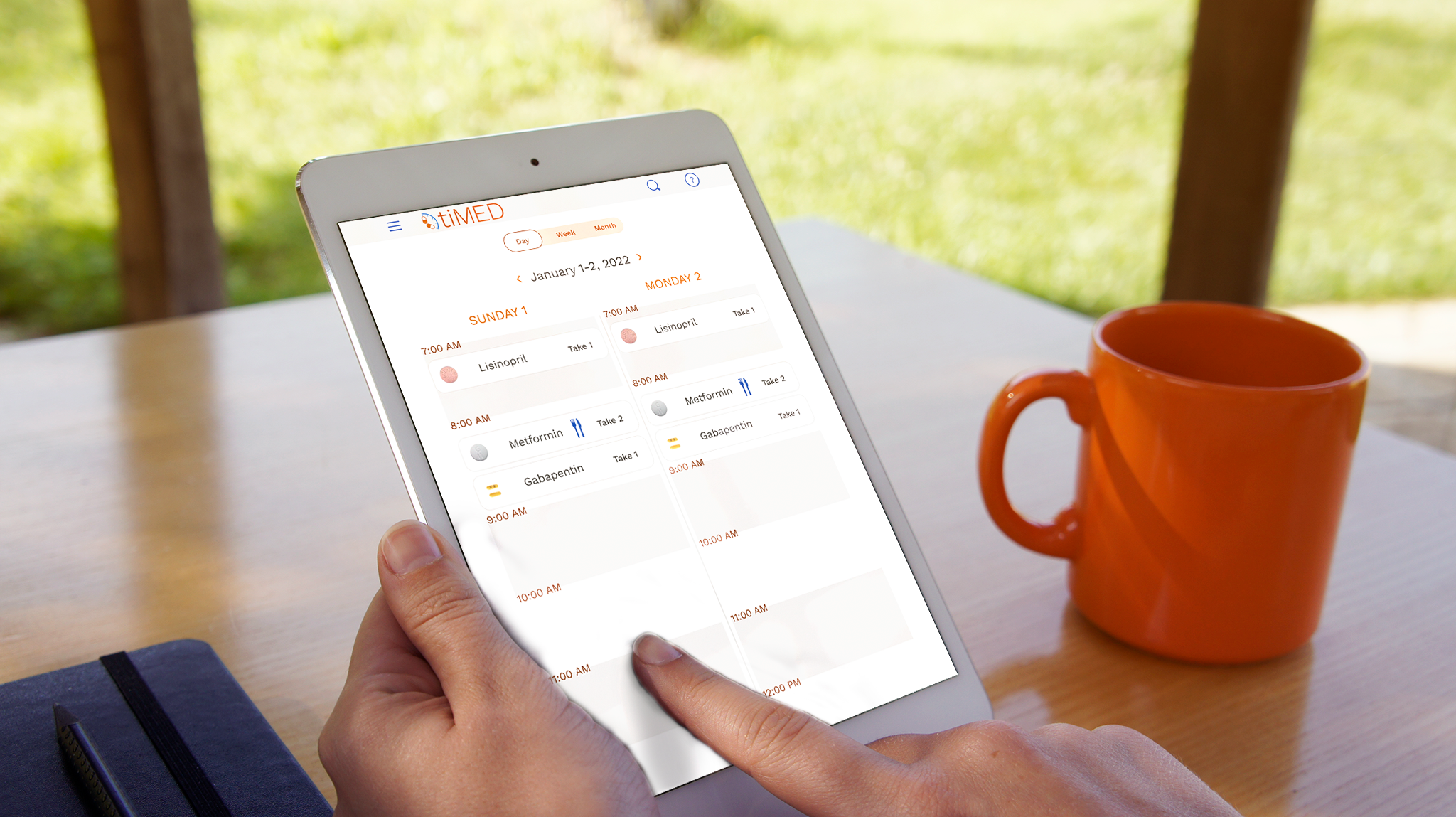 Hand holding a tablet computer, looking at a two-day medication schedule.